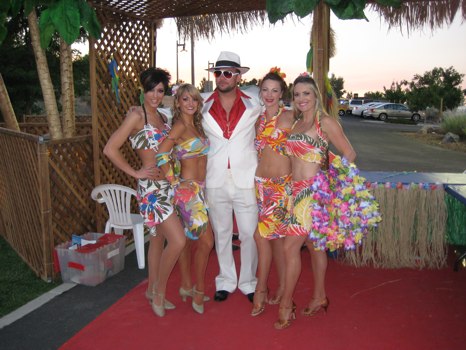 Man in suit and girls in tropical gear at party
