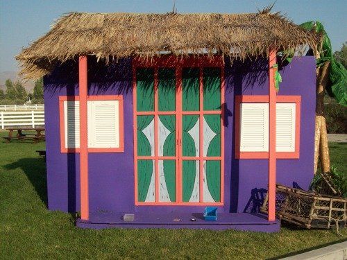 Purple thatch roof house as prop for island themed party.