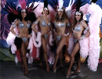 Four women in pink costume with feathers